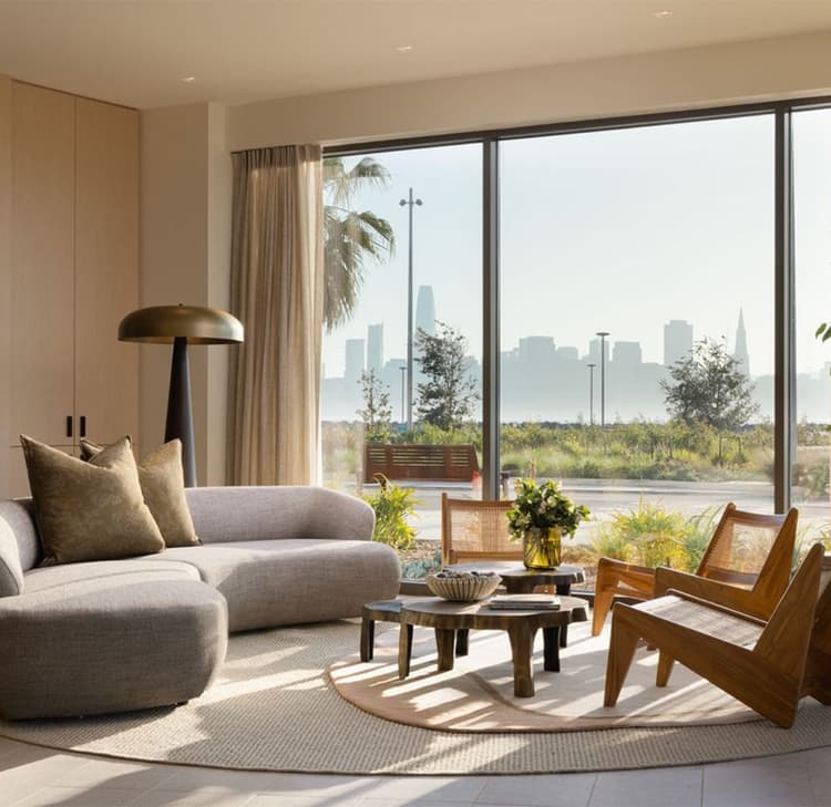 nterior lounge at 490 Avenue of the Palms with modern seating, floor-to-ceiling windows, and views toward the San Francisco skyline.