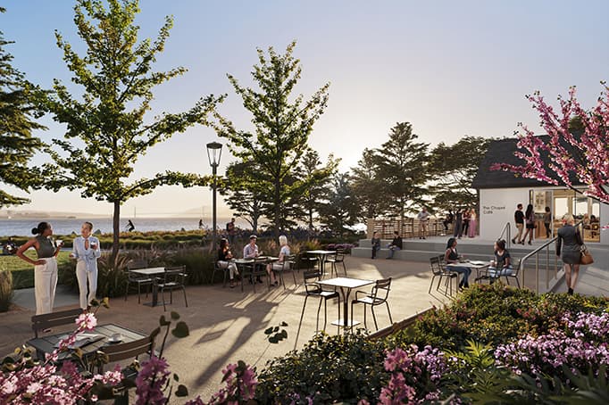 Outdoor plaza at Chapel Grove with café tables, landscaped gardens, blooming flowers, and people gathering beside the chapel on a sunny waterfront day.